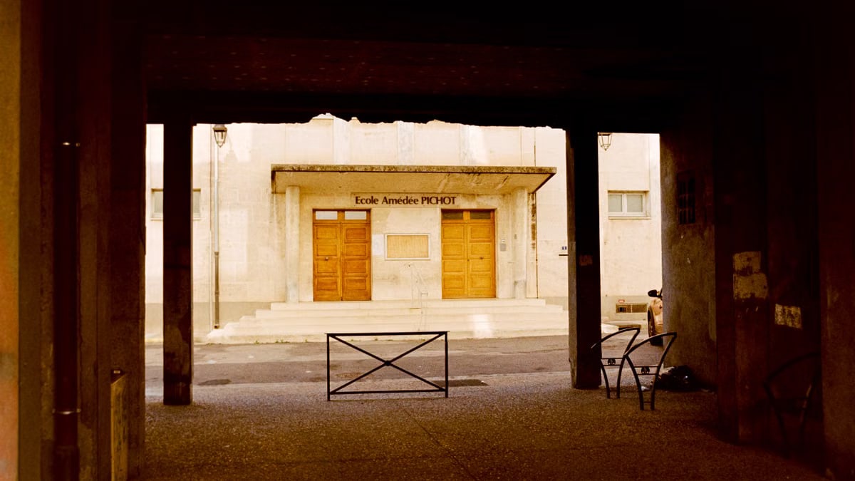View of Ecole Amédée Pichot in Arles, France, framed by an archway.